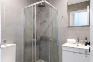 a bathroom with a shower with a toilet and a sink at Yamas Urban Living Olympia Suites in Limassol +12 photos