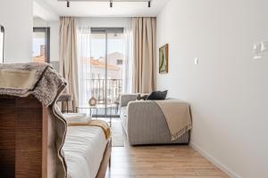 a living room with a couch and a bed at Yamas Urban Living Olympia Suites in Limassol