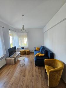 a living room with a blue couch and a chair at Apartament h2o in Giżycko