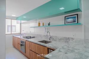 a kitchen with a sink and a counter top at Apto em condomínio beira-mar Itacimirim-BA IAB109 in Camacari +4 photos