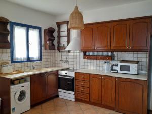 a kitchen with wooden cabinets and a stove top oven at Wide sea Maisonette in Agios Dimitrios