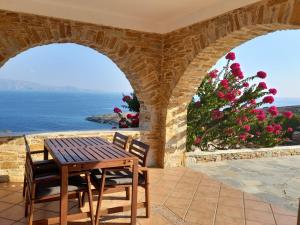 a table and chairs on a patio with a view of the ocean at Wide sea Maisonette in Agios Dimitrios