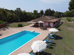 a pool with chairs and umbrellas next to a house at Αρετή in Amaliás +3 photos