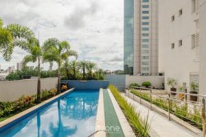 a swimming pool on the roof of a building at Studio em cond. com piscina e academia - LHG1603 in Goiânia