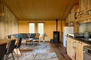 a kitchen and living room with a table and a refrigerator at Glamping Franse Peer in Hasselt
