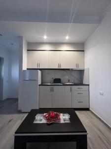 a kitchen with white cabinets and a black table at Vokopola Villa in Sarandë +10 photos