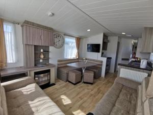 a living room with a couch and a table at The Retreat Gold - Lido Beach Prestatyn in Prestatyn