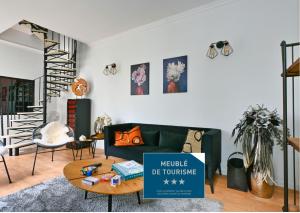 un salon avec un canapé vert et une table dans l'établissement Maison climatisée Gare à 10 min, idéale familles MaisonCarréeConciergerie, à Nîmes