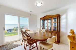 ein Esszimmer mit Tisch und Stühlen und einem großen Fenster in der Unterkunft Harbor Village Lakeview Condo 902-3 in Garden City