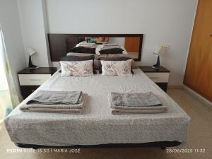 a bedroom with three beds with towels on them at Disfruta Granada, Parking y Mascotas in Granada