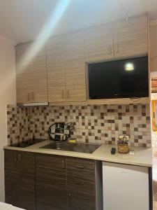 a kitchen with a sink and a microwave at Vokopola Villa in Sarandë