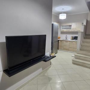 a large flat screen tv on a wall in a living room at Potamos Townhouse & Shared Garden in Potamós