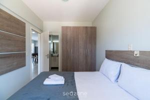 a bedroom with a large bed with a wooden headboard at Apto Charmoso a 550m da Praia Perequê - RNE0301 in Perequê +6 photos