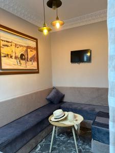 una camera con un divano e un cappello su un tavolo di Riad Le Marrakech Berrima a Marrakech