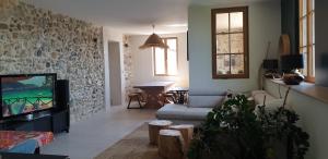 a living room with a couch and a tv at Le château in Annecy