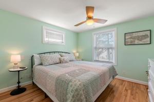 Un dormitorio con una cama y un ventilador de techo. en Bris Bungalow, en Nags Head