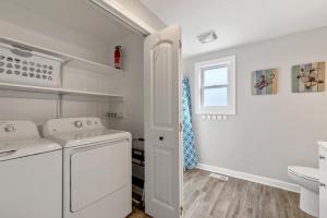 Un lavadero blanco con lavadora y secadora. en Bris Bungalow, en Nags Head