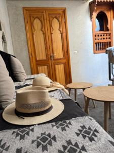 un cappello poggiato sopra un letto di Riad Le Marrakech Berrima a Marrakech