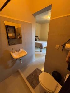 a bathroom with a toilet and a sink and a bed at Jungla Bacalar in Bacalar +130 photos