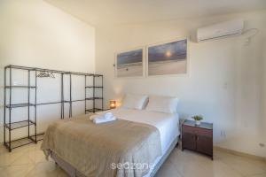 a bedroom with a large bed and a night stand at Casa 6Q pé na areia em Bombinhas ABM0101 in Zimbros +8 photos