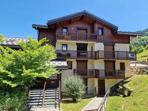 an apartment building with balconies on a hill at Chalets des Evettes- appartement vue montagne in Flumet +13 photos