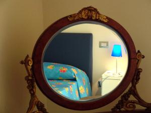 um espelho com uma cadeira e um candeeiro num quarto em Caracciolo 10 em Nápoles