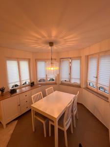 a dining room with a table and chairs and windows at Großes Apartment 74m2 mit Balkon & Parkplatz - Steakhouse Esmeralda in Ebersbach-Musbach