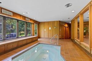 W pokoju z oknami znajduje się duża łazienka z wanną z hydromasażem. w obiekcie Nature's Retreat 4-Bedroom Cabin w mieście Honesdale