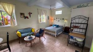 una camera da letto con un letto, un divano e un tavolo di Jacoway Inn a Calibishie