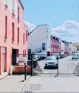 アミアンにあるAppartement 2 personnes sur Amiensのピンク色の建物とフェンスのある街路