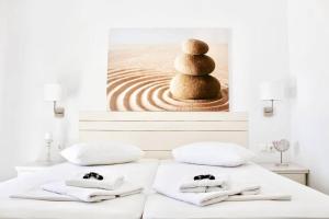 a bed with a picture of a stack of rocks at Aegeo Inn in Antiparos