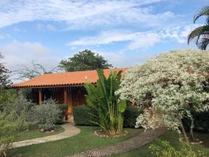 圣代佩德罗Pousada Estância Travessia的一座带花园和鲜花树的房子