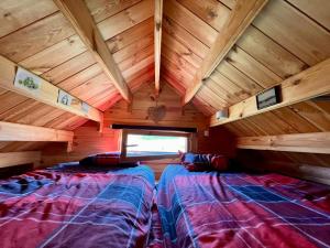 a room with two beds in a wooden cabin at La casita in Villefranque