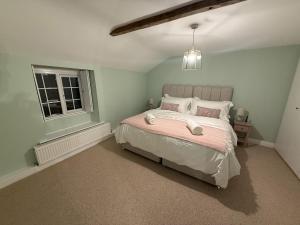 En eller flere senge i et værelse på Woodman's Cottage