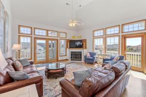 a living room with leather furniture and a fireplace at By Grace in Kill Devil Hills