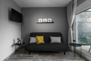 a living room with a couch and a window at "HoMes" II, The aRt BoutiQue experience by Lou Lenny in Kallithea Halkidikis