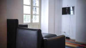 a living room with two chairs and a television at Força Old Town in Girona