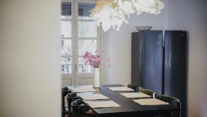 a dining room table with a black refrigerator in a room at Força Old Town in Girona