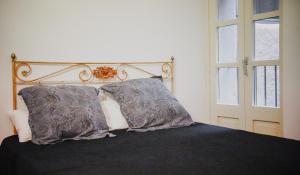 a bedroom with a bed with two pillows and a window at Força Old Town in Girona