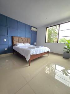 a bedroom with a bed with a blue wall at Luminoso, Moderno, Pisicina in SamborondÃ³n +40 photos