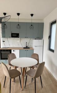 a kitchen with a white table and chairs at HiL's Bay View Apartments in Tivat