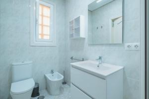 ein weißes Badezimmer mit Toilette und Waschbecken in der Unterkunft El Pez Volador by Gades Gestión in Cádiz + 18 Fotos