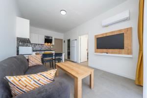 a living room with a couch and a tv on a wall at Dede Suites Fethiye in Fethiye