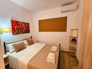 a bedroom with a bed with two towels on it at Corfu Dream Holidays Villas in Glyfada