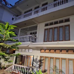 a large white house with a balcony at Tranquil Trails Homestay in Guwahati +14 photos