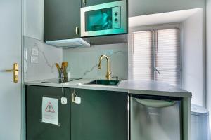 une cuisine avec un évier et un micro-ondes dans l'établissement Cupidon Room, à Montgeron