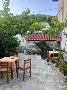 a patio with tables and chairs and a building at Luigi Guest House in Gjirokastër