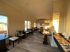 un restaurante con mesas y sillas y una barra con comida en Achalay Colonia Dora Hotel Boutique, en Colonia Dora