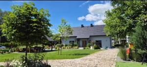 a house with a gravel driveway in front of it at Osada Ostrowsko in Uniejow