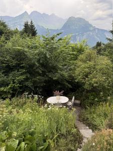 a table and chairs in a garden with mountains in the background at Chalet Montana mit Bergblick in Brunig